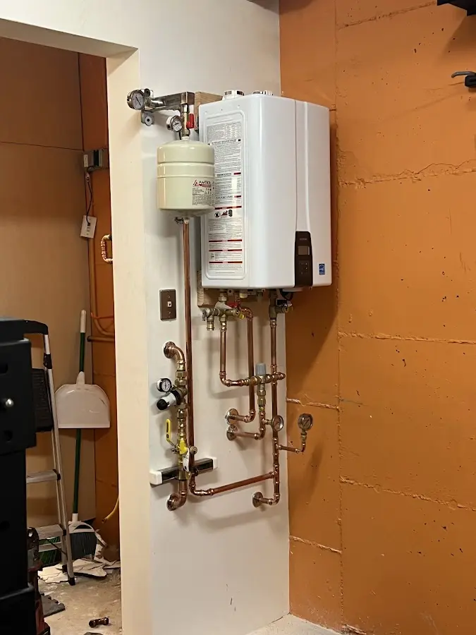 Plumbing technician inspecting water heater connections in Spokane Valley